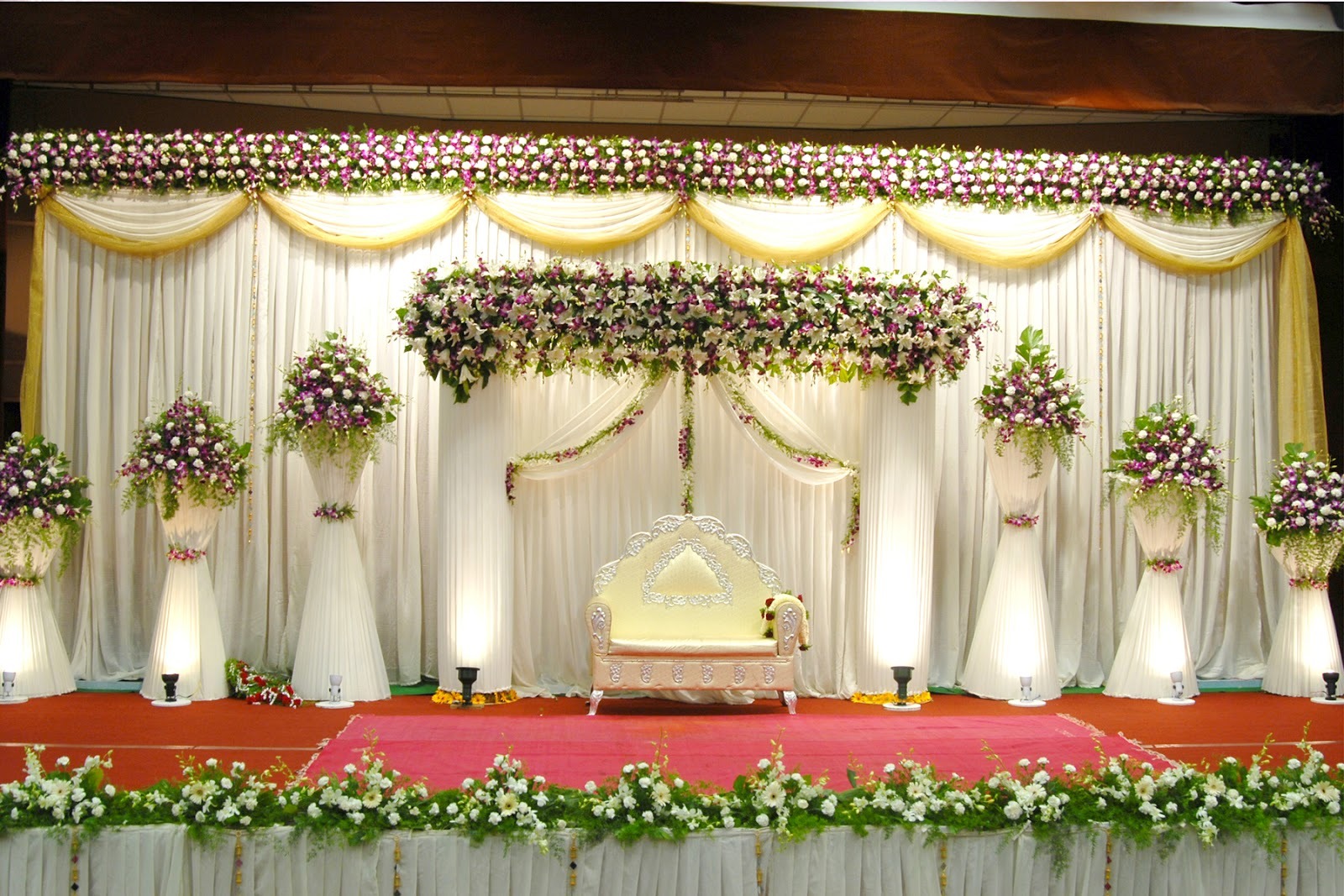 Beautifully decorated baby shower stage with soft pastel-colored drapery, floral arrangements,